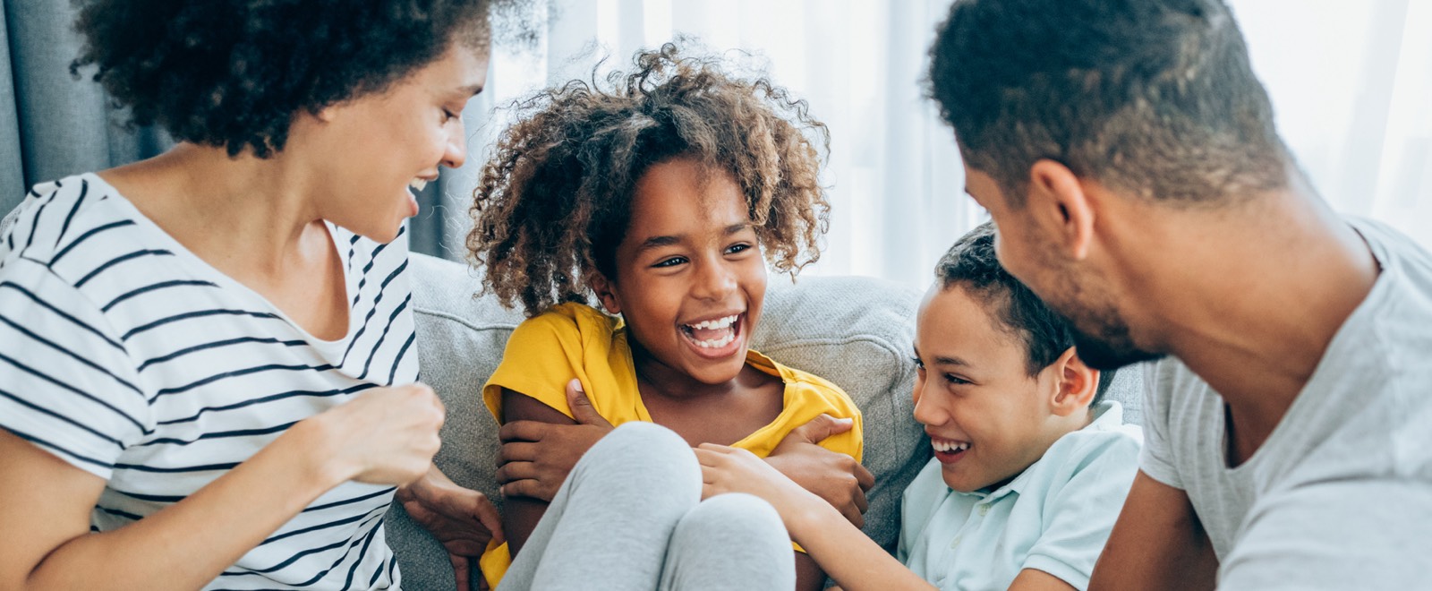 A young family sitting together on a couch