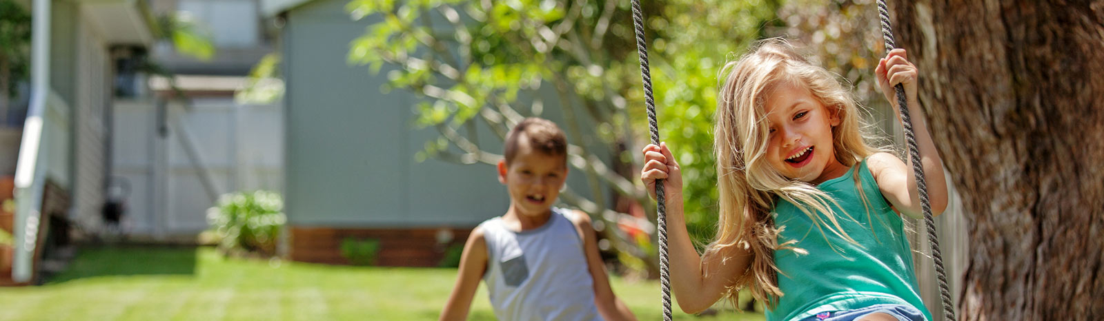 Two young kids playing on a swing