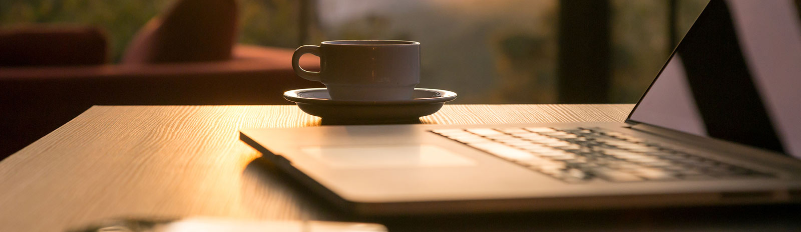 Close up of a laptop and coffee cup