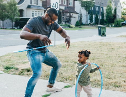 A dad and toddler playing with hulahoops