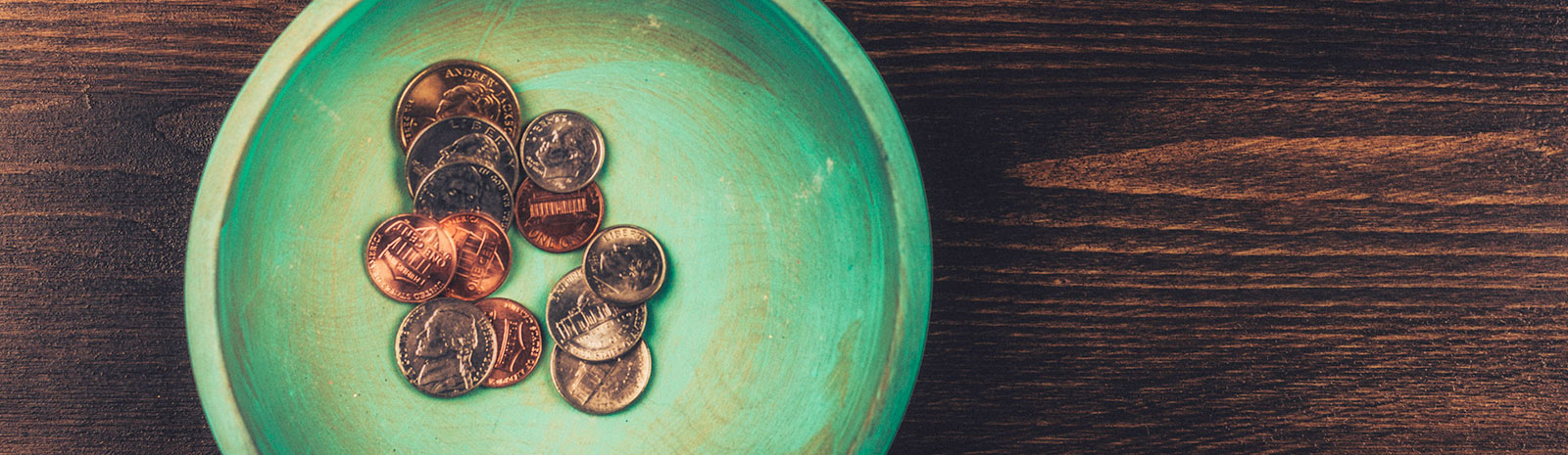 Top-down view of USD coins sitting in a green bowl